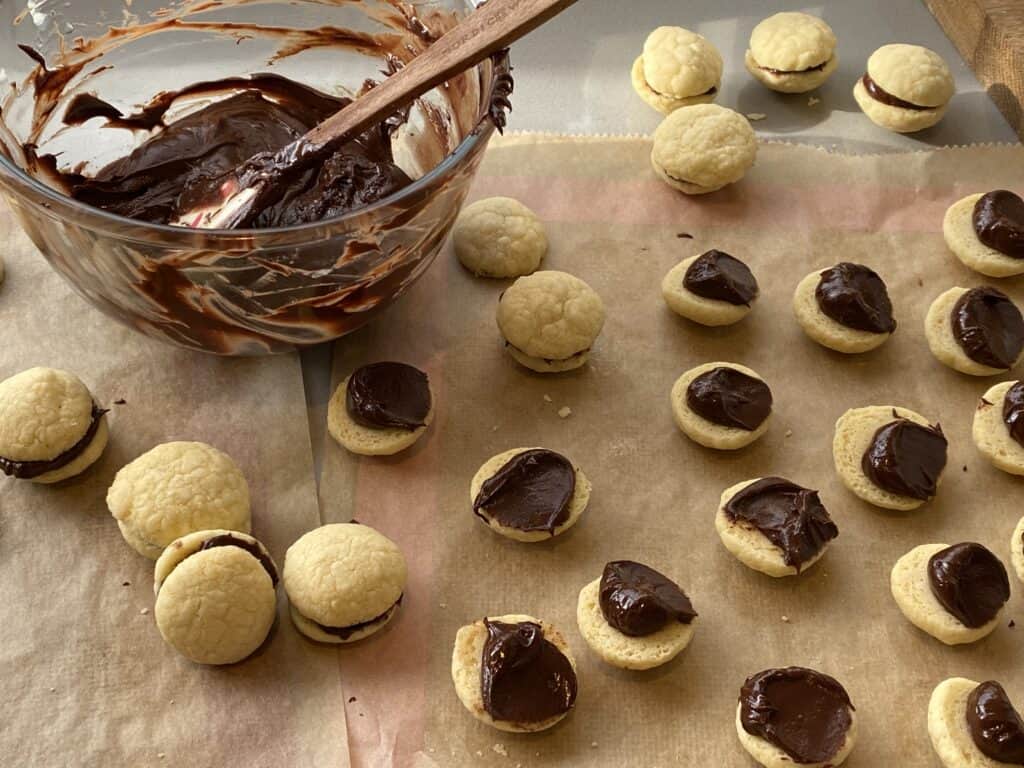 Little baked biscuits and melted chocolate in a glass bowl