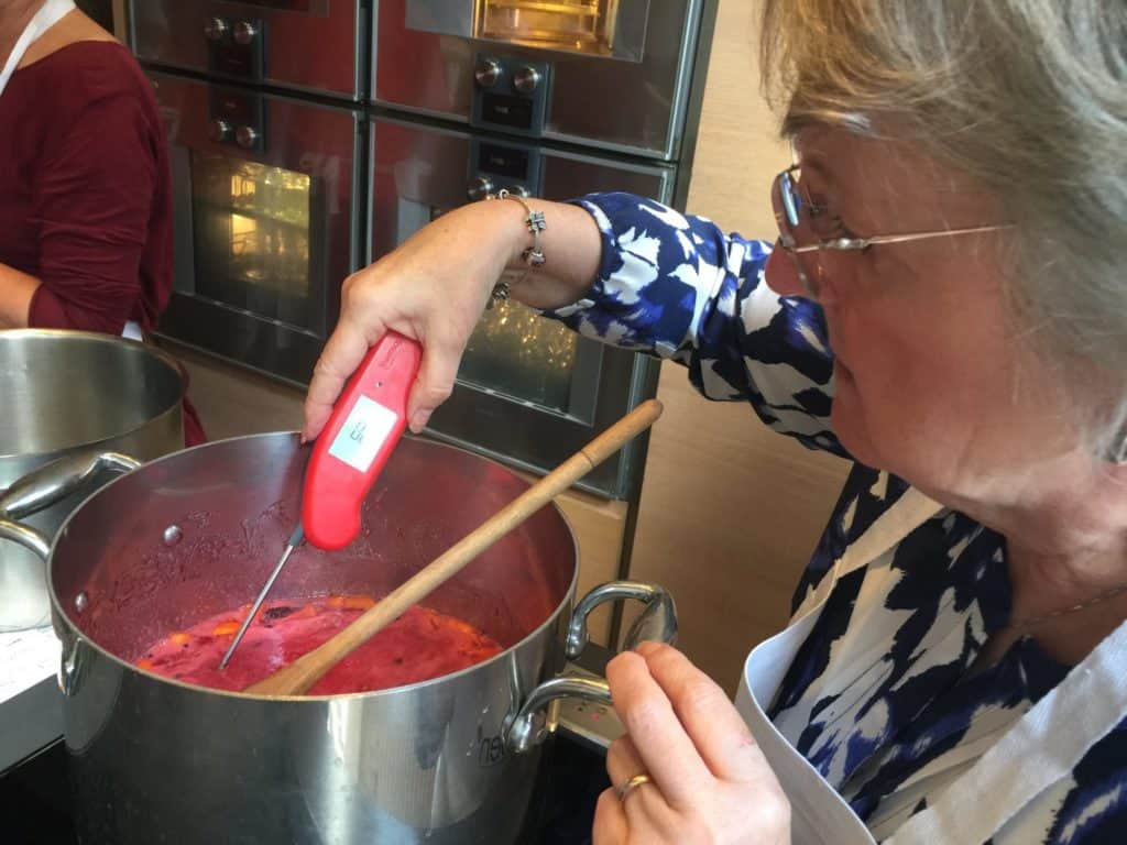 Testing a large cooking pot of jam using a digital thermometer