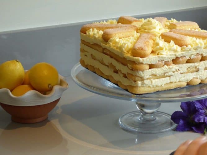 Lemon sponge fingers icebox cake on a glass cake stand