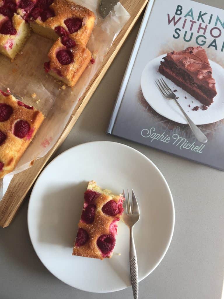 Cook book and slice of cake on a white plate