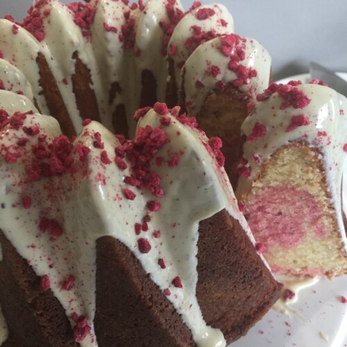 White Chocolate and Raspberry Cake with a slice cut out