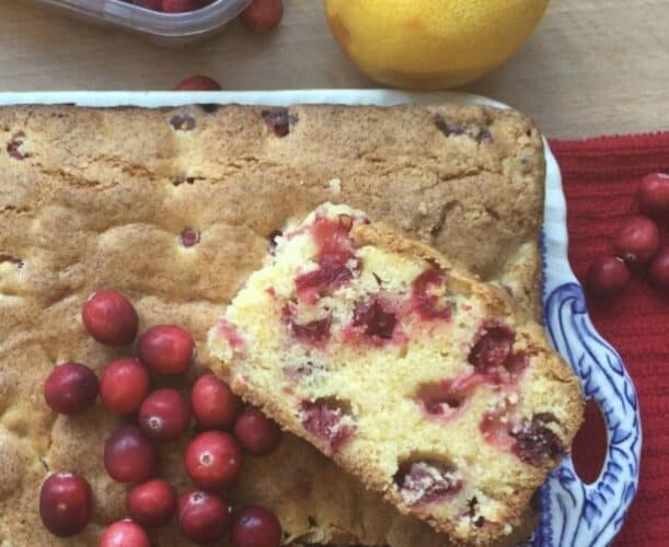 Slice of cranberry and orange cake on a blue plate.