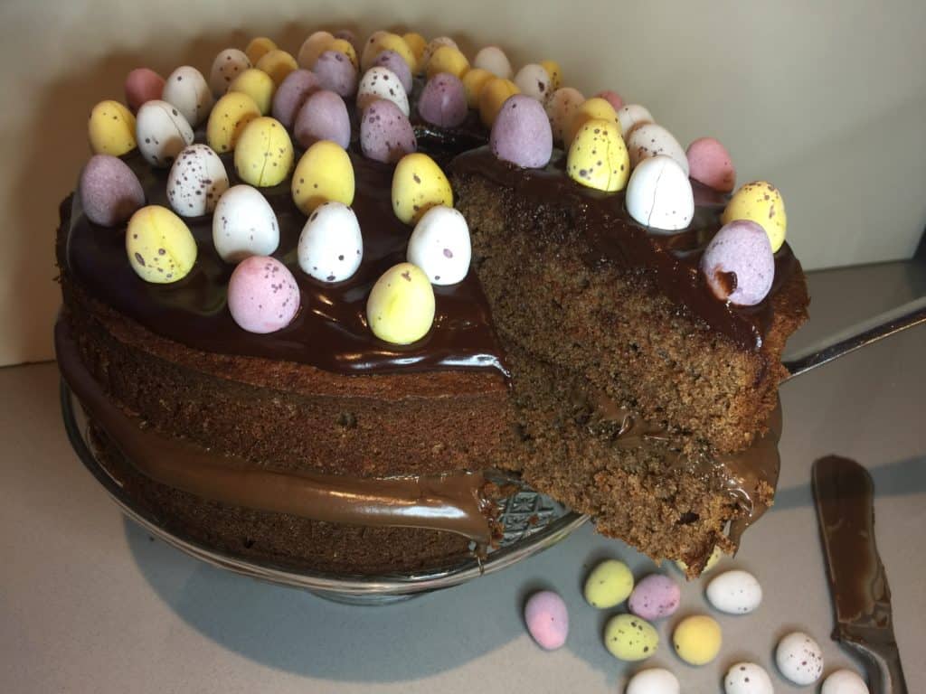 Chocolate Cake. Decorated with mini sugar coated eggs. Displayed on a glass cake stand. 