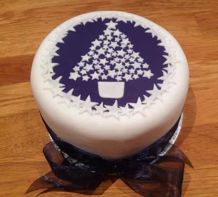 Fondant covered cake with blue base and white fondant stars creating a Christmas tree