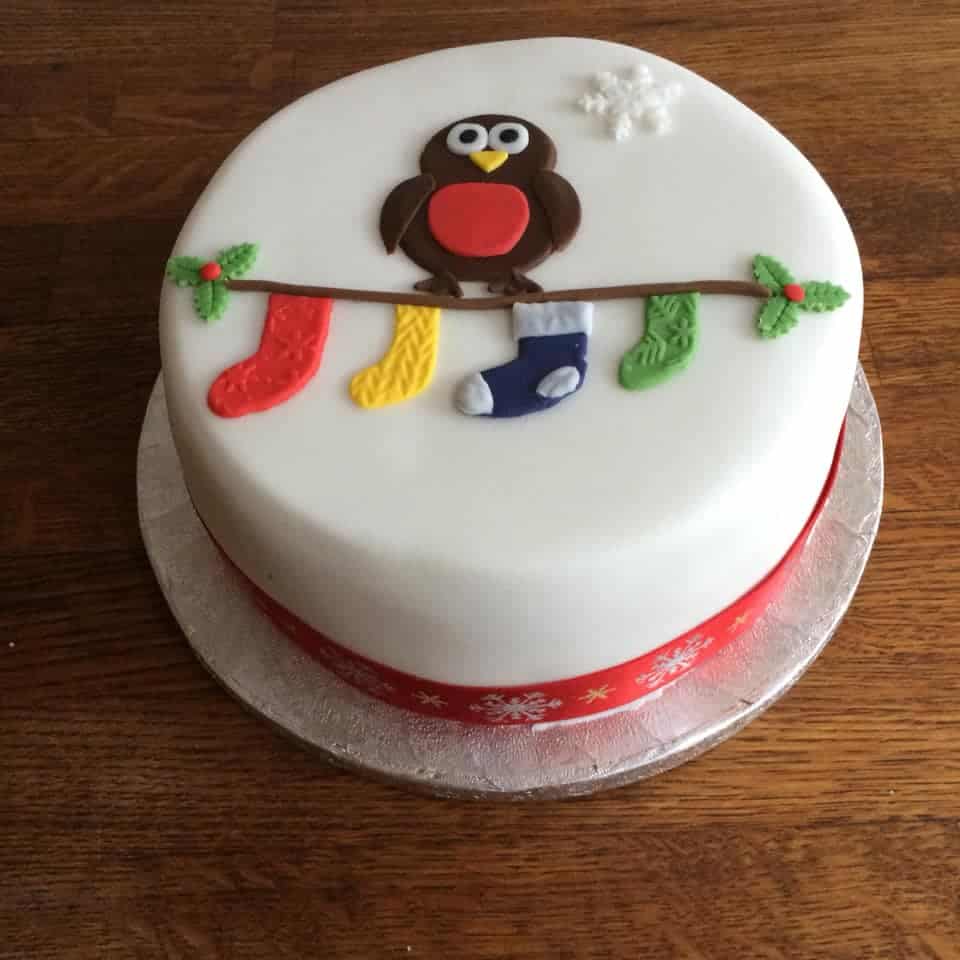 Fondant covered cake with an owl on a branch holding christmas stockings