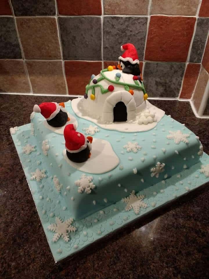 Cake with Fondant cake toppers shaped like penguins and an igloo