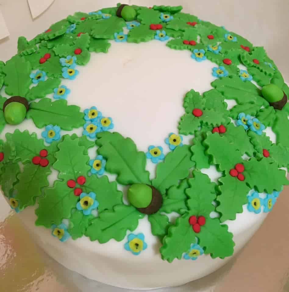 Decorated Christmas cake with white fondant and a wreath of fondant holly