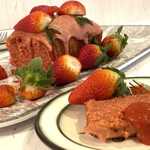 Strawberry cake on a grey dish with fresh strawberries