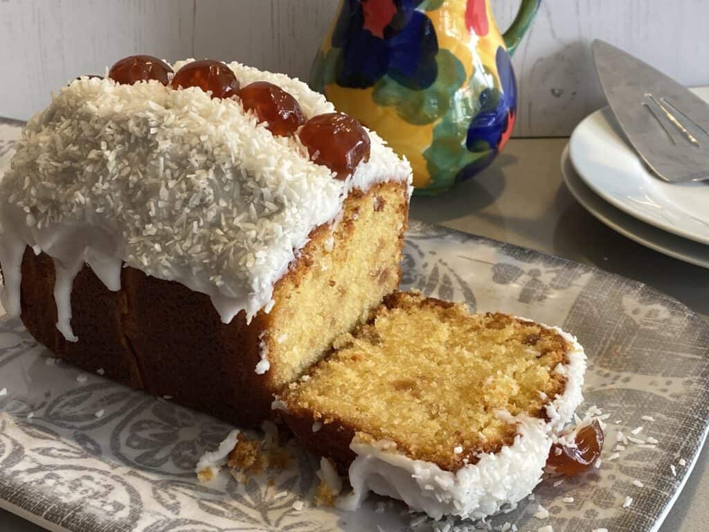 Cherry and Coconut Cake with a slice cut out.