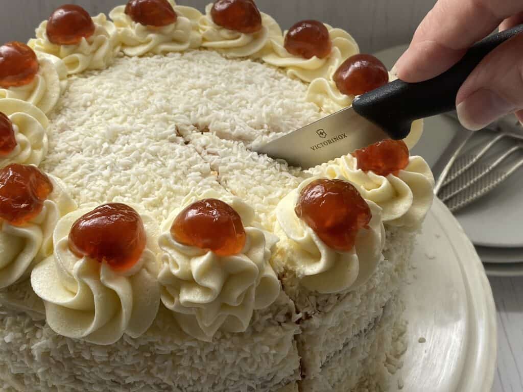 Cutting a slice of coconut cake