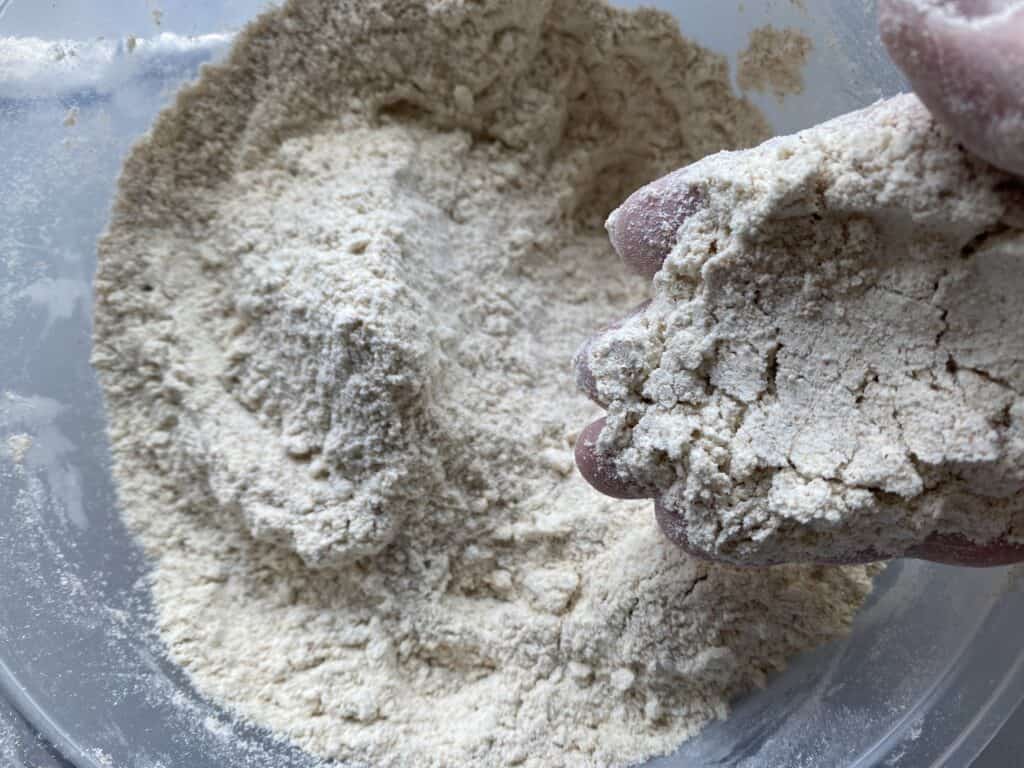 Hand mixing flour in a bowl