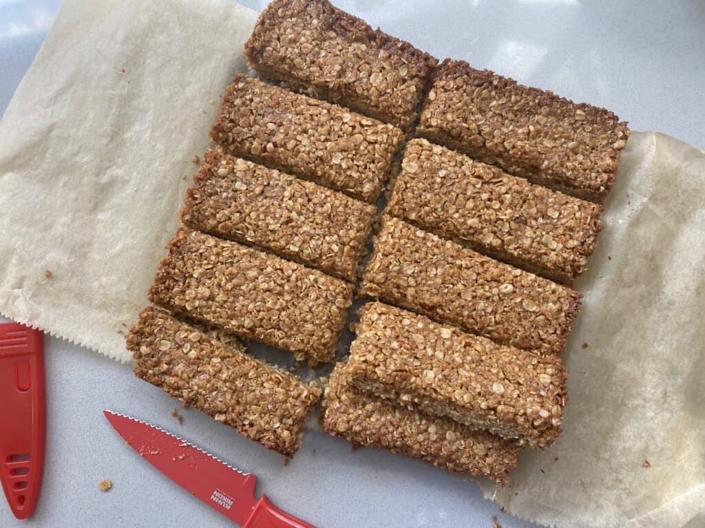 Overhead shot of sliced flapjacks oat bars with a red knife