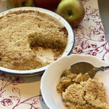 Apple Crumble with a portion served in a white dish.