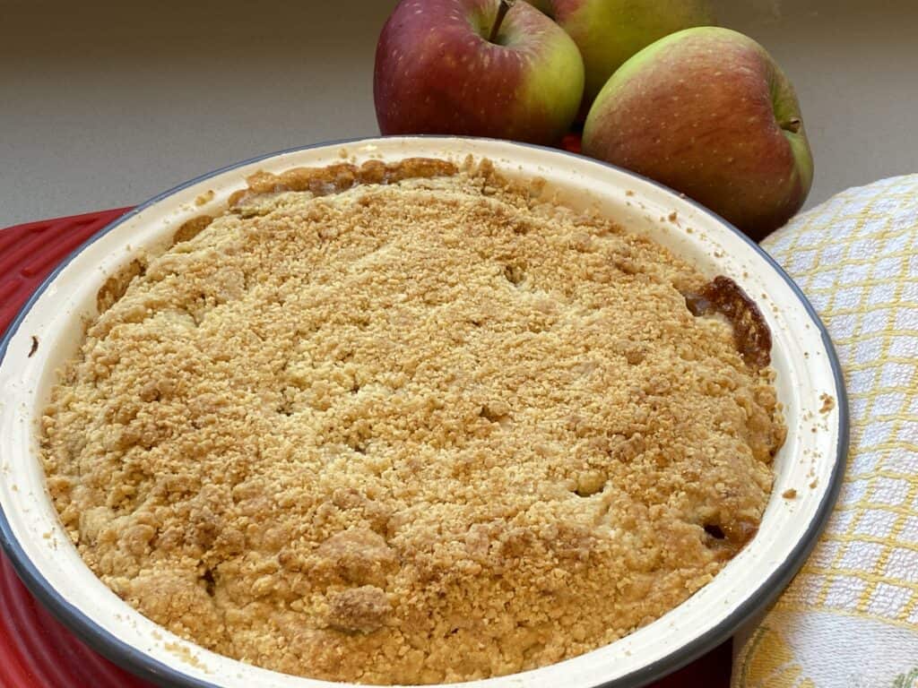 Baked Apple Crumble with fresh red apples on the side