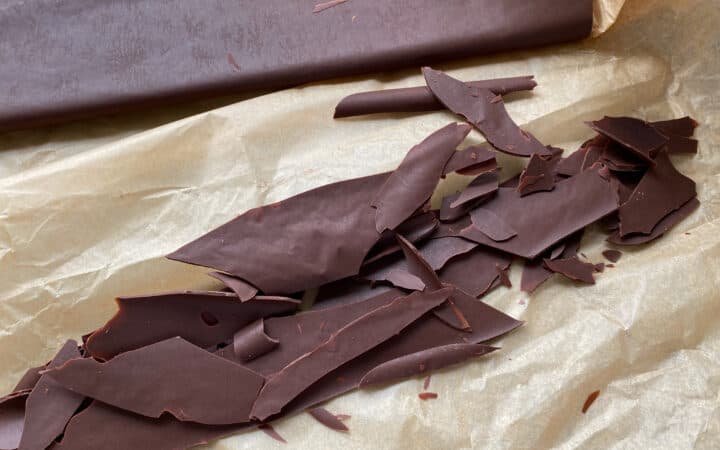 Chocolate shards on a sheet of baking parchment