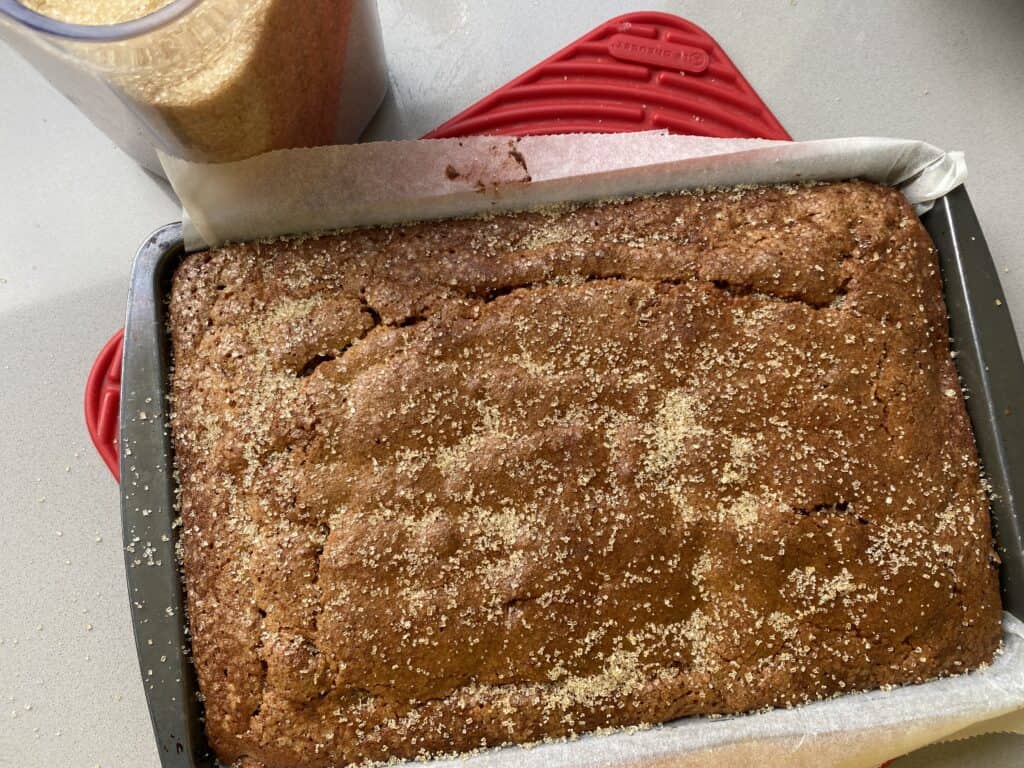 Baked tray bake with container of sugar on the side.