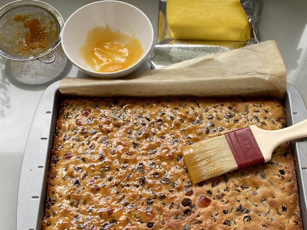 Fruit Cake being brushed with apricot jam